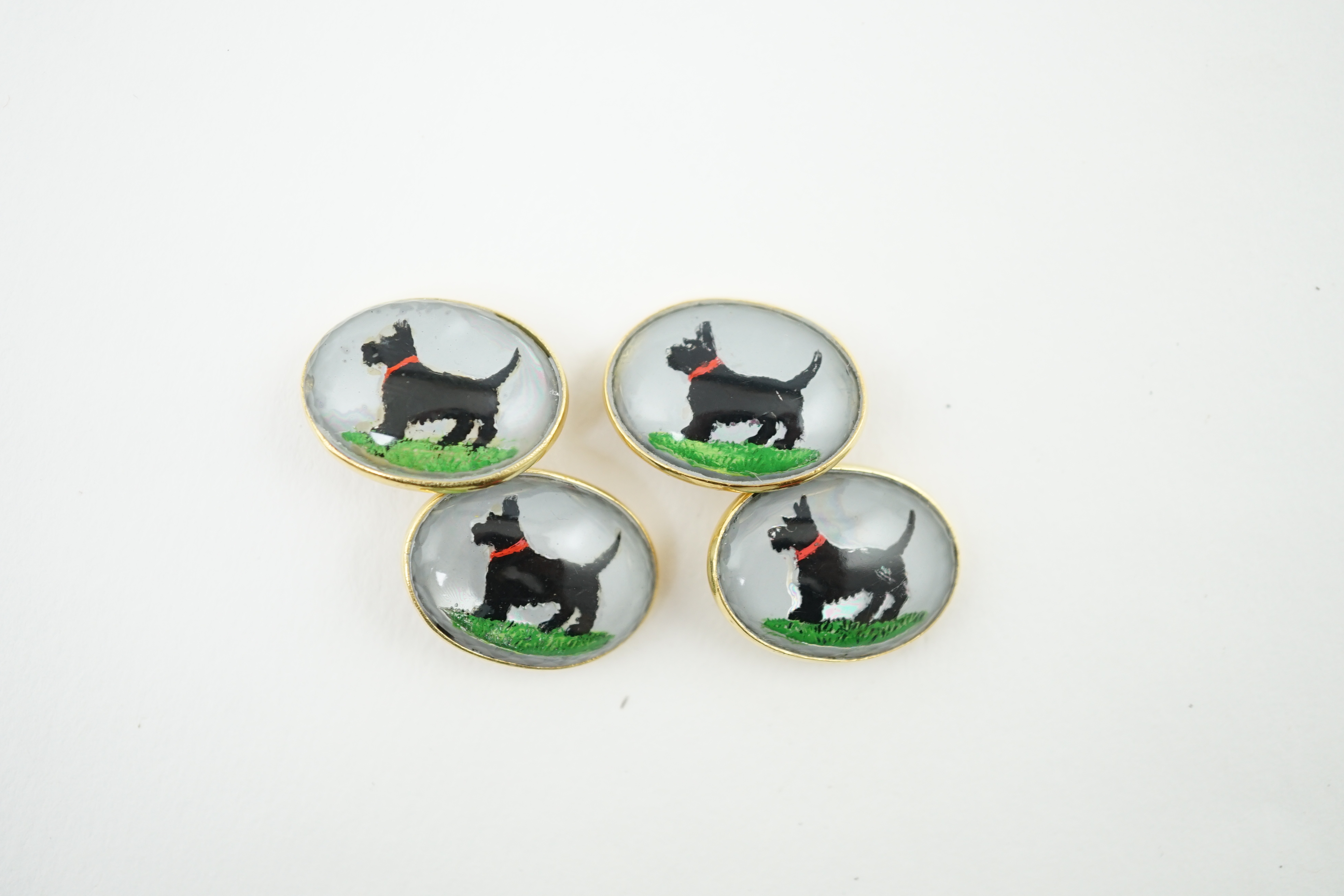A pair of early to mid 20th century gold and Essex crystal set oval cufflinks, each decorated with a Scottie dog, 20mm, gross weight 23.4 grams. Condition - fair